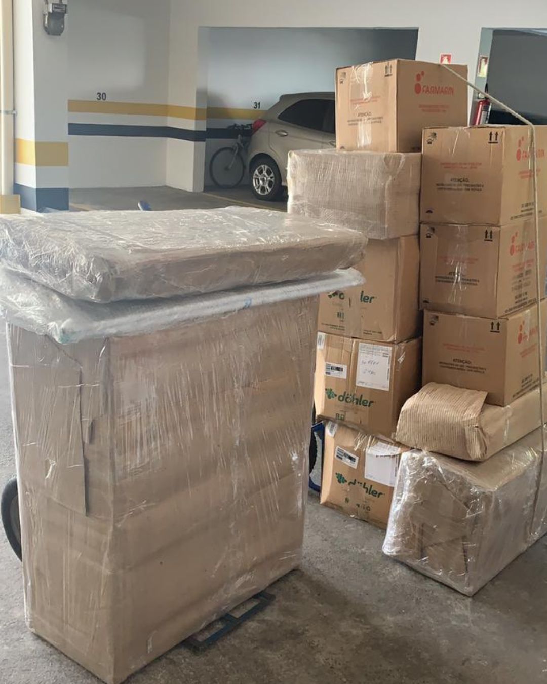 Móveis embalados com filme e caixas empilhadas em uma garagem