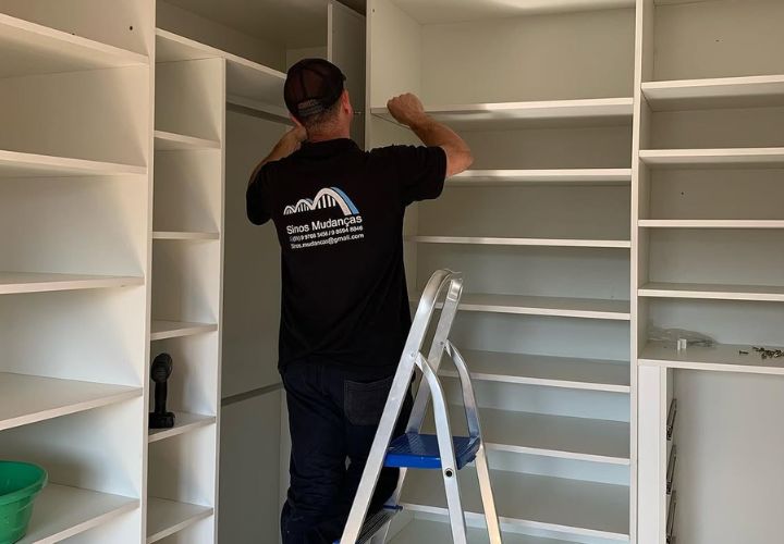 Profissional da Sinos montando um móvel durante a mudança